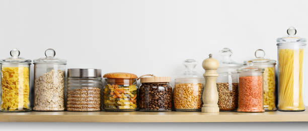 istock Kitchen shelf for storing food in glass jars on a white wall background 1752750623