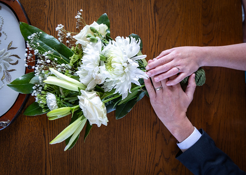 two hands holding  a bouquet