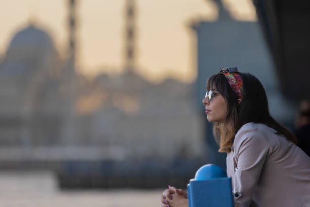 Pretty young lady is looking sunset view at city of Istanbul.