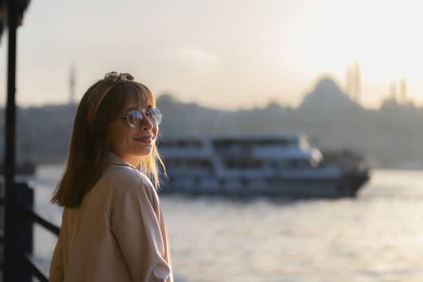 Pretty young lady is looking sunset view at city of Istanbul.