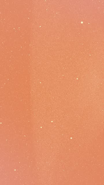 Sand beige tiny dots glitter on orange coral gradient background that form an abstract figure with itself. Vertical stars backdrop party or Christmas holidays and New Year concept with copy space
