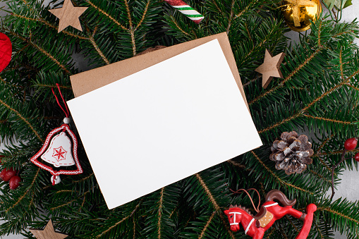 Christmas 5x7 card mockup template with envelop on natural fir twigs background. Design element for Christmas and New Year congratulation, rsvp, thank you, greeting or invitation card