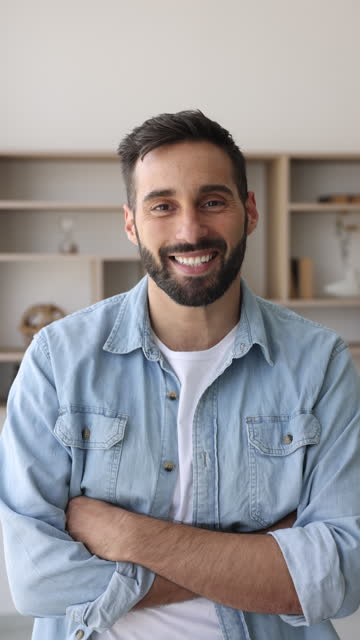 Happy bearded millennial Hispanic employee standing alone indoor