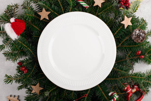 istock Christmas table setting with white ceramic plate on natural fir branches background. 1752834892