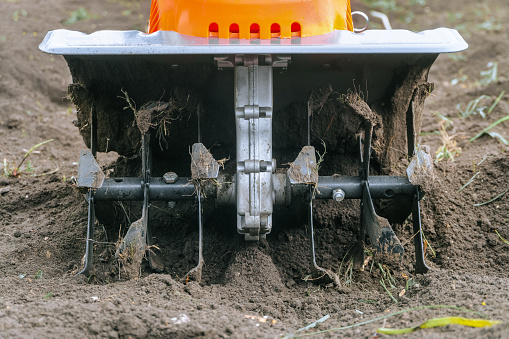 Ripper knives of electric cultivator for cultivating soil in vegetable garden. Front view close up.