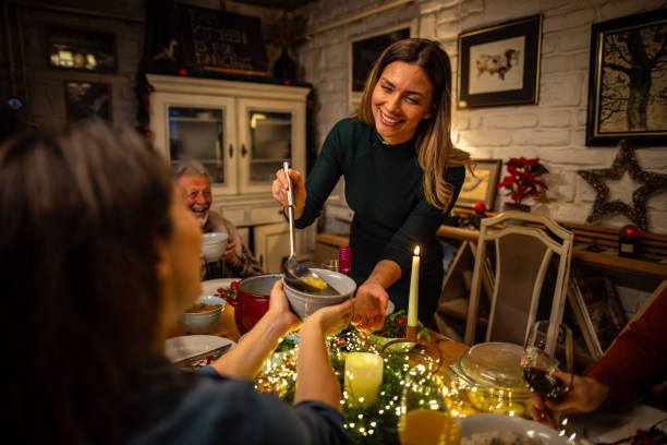 Young woman serving a soup during the Christmas dinner