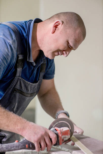 istock Professional tiler cutting tile with angle grinder. Construction, renovation, repair apartment. 1752880977