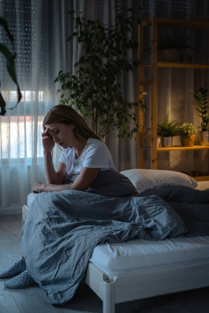 istock Sad young woman sitting in bed and suffering from insomnia 1752901552