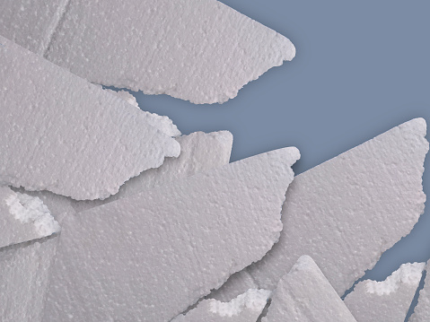 a bunch of crushed white styrofoam stacked on a blue background