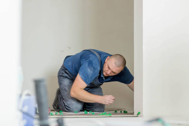 istock Tiler placing ceramic wall tile in position over adhesive with lash tile leveling system. Ceramic Tiles. 1752951016