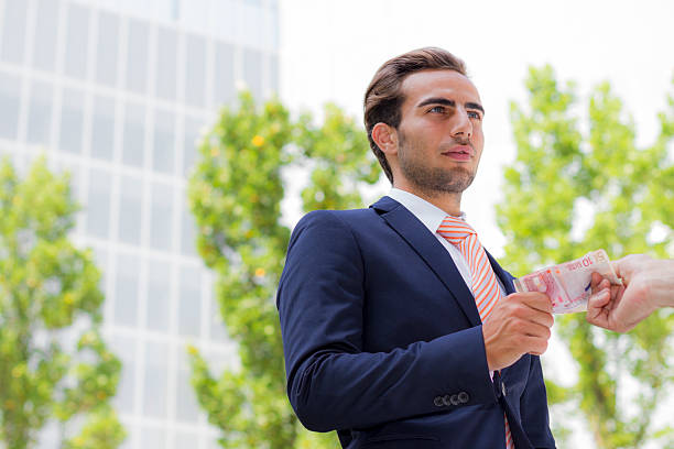 istock Young businessman outside office taking banknotes 175309774