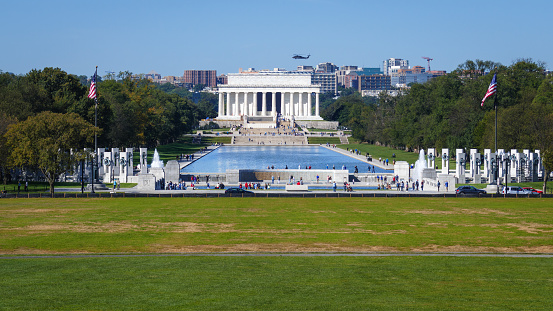 Photo of a helicopter flying over the Lincoln Memorial taken from the National Mall in Washington DC in the United States of America.