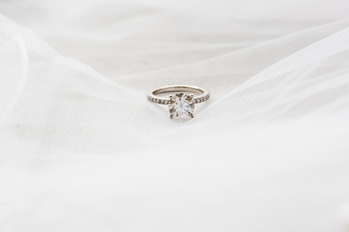 Beautiful diamond engagement ring on a white veil