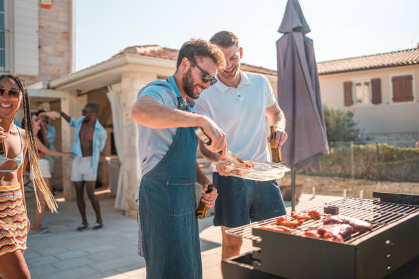 Hispanic Male Grilling Delicious BBQ by the Villa Pool stock photo