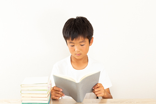 A boy reading in his room.