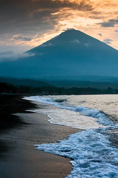 The active volcano Gunung Agung seen from the black sand beach in the village of Jemeluk, Amed in the eastern part of the tropical paradise known as Bali.