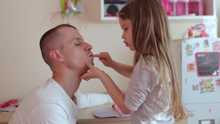 a little girl does her father's makeup