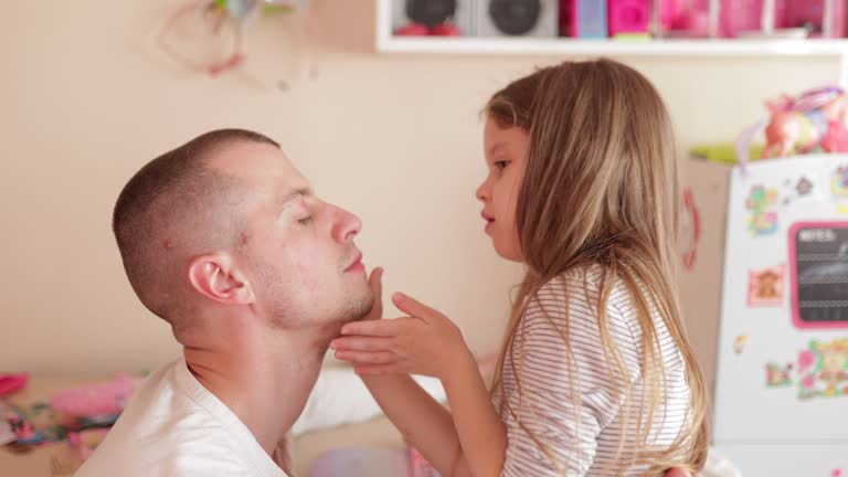 Little daughter and father have fun-daddy makeup