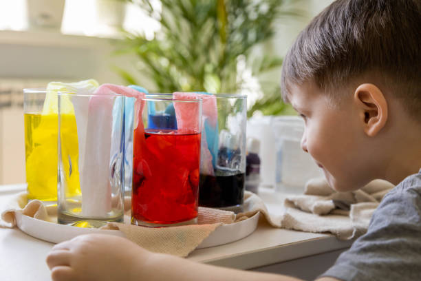 istock Cute baby boy learning mixing different colors with water and paint in containers. Early development 1753370955