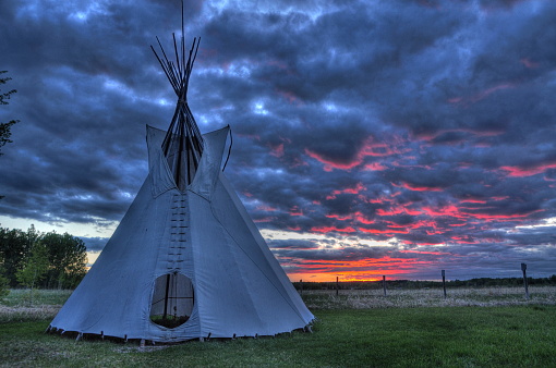 Silhouette of a Native American  teepee on landscape at sunrise, Browning, Montana, USA.