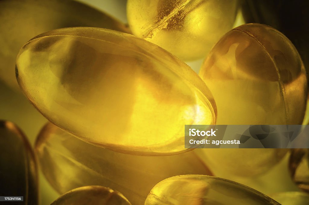 Omega 3, vitamin D, fish oil capsule Golden colored fish oil capsules Close up Macrophotography Stock Photo