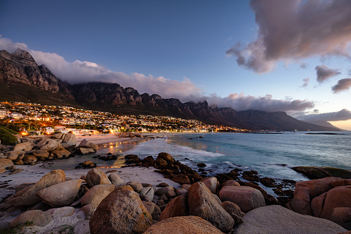Cape Town Sunset Twilight - Camps Bay Suburb in Summer. Famous Camps Bay Scenic View in beautiful and colourful. moody Sunset Twilight. Illuminated Camps Bay Houses, Restaurants and Villas in the famous suburb of Cape Town with white sandy beaches underneath the Table Mountain. Cape Town, South Africa, Africa