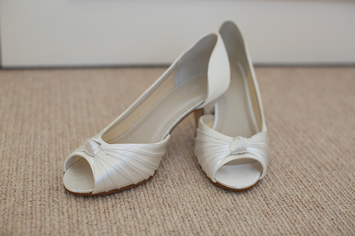 Wedding day with brides shoes sitting on carpeted floor