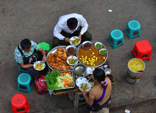 Yangon, Myanmar - Feb 1, 2017. People eating street food in Yangon, Myanmar. Yangon is the country's main centre for trade, industry and tourism.