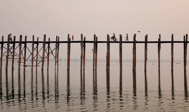 Mandalay, Myanmar - Feb 21, 2016. Local people walking on U Bein Bridge in Mandalay, Myanmar. U Bein Bridge is believed to be the oldest and longest teakwood bridge in the world.