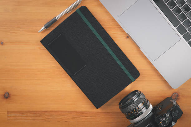 istock Top view of wooden table with computer laptop, camera, notebook and pen 1753502296