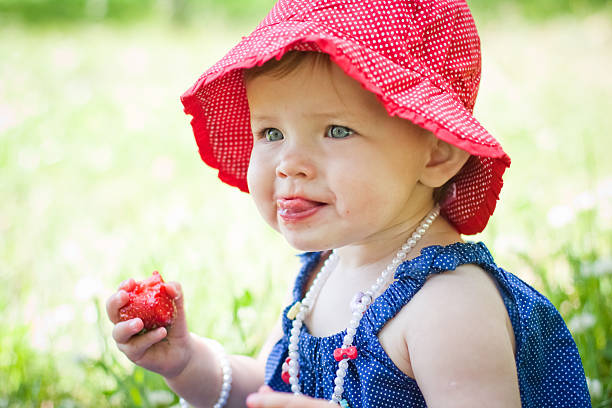 child is eating strawberry in summer