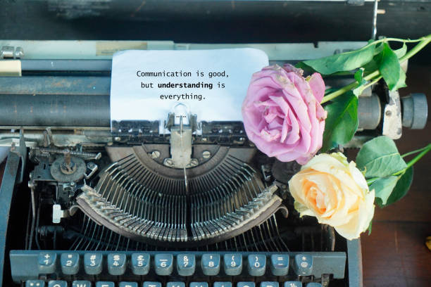 Message on white paper - Communication is good, but understanding is everything. With two roses on  old rusty typewriter.