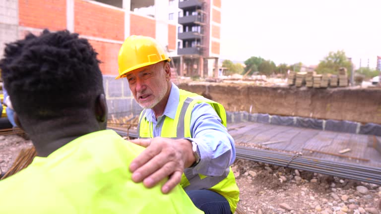 Senior man consoling his colleague at construction site