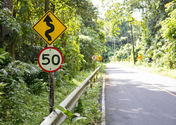 istock Traffic sign, speed sign 50 Kilometers per hour and complex curves ahead are installed alongside asphalt roads to inform road users of danger and caution. 1753580617