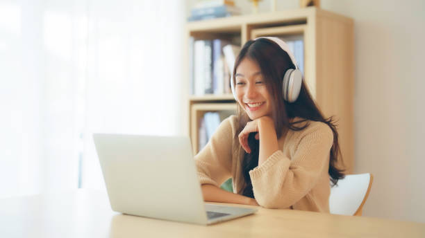 istock Young asian woman wearing headset while working on computer laptop at house. Work at home, Video conference, Video call, Student learning online class 1753591564