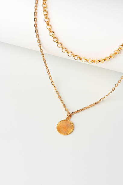 istock Golden chain with pendant on paper background close up 1753592154