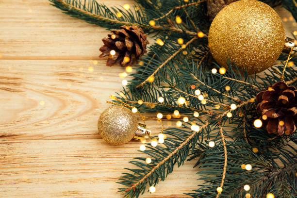 istock Christmas background for greetings. Green branches of coniferous tree and dry pine cone on a light wooden background 1753592676