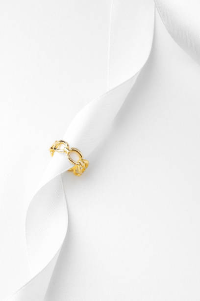 istock Golden jewelry ring on ribbon studio shot 1753598171