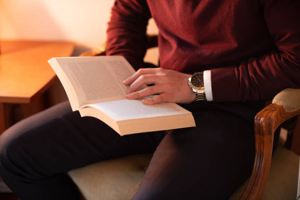 istock Well dressed man reading in home library, sitting in old chair 1753621103