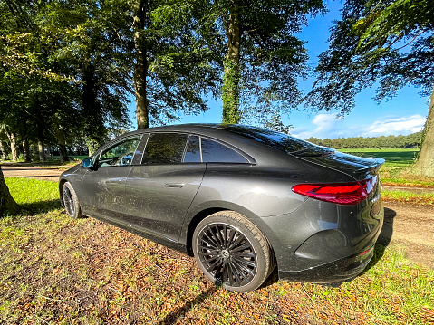 Mercedes-Benz EQE full electric luxury car parked on the side of a country road in nautre during an autumn day. The Mercedes-Benz EQE (V295) is a full electric executive car and one of the models of the Mercedes-Benz EQ family produced by German automobile manufacturer Mercedes-Benz Group.