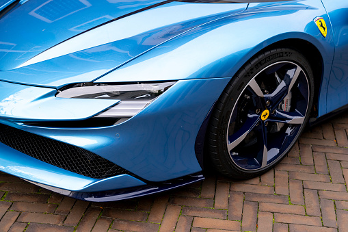 Ferrari SF90 sports car in light blue parked on the street in Zwolle. The Ferrari SF90 Stradale, unveiled in 2019, is a hybrid sports car and the first series-production Plug-In Hybrid Electric Vehicle (PHEV) from Ferrari. The SF90 Stradale is powered by a 4.0-liter twin-turbocharged V8 engine coupled with three electric motors – two at the front and one at the rear.