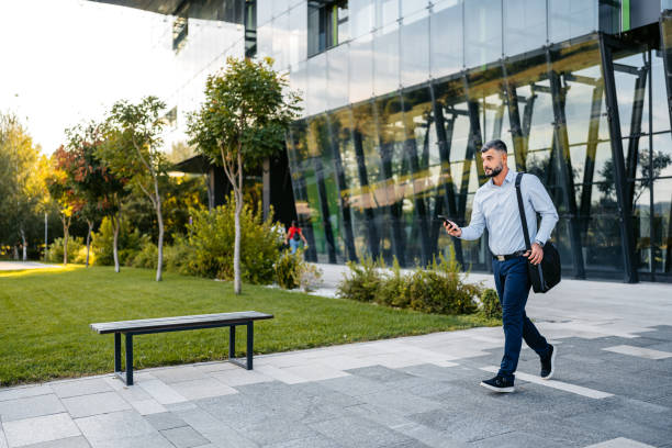 Adult Man Leaving His Office And Checking His Phone