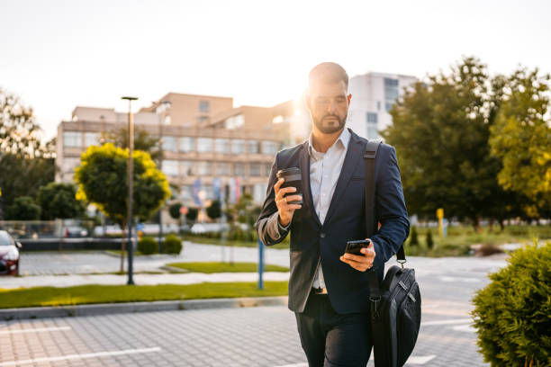 istock Businessman Using Phone And Drinking Coffee In Front Of Corporate Building 1753670038