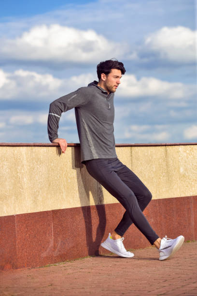 istock Caucasian Active Handsome Athlete Male Runner During Sporty Fit Young Man Jogging by River Bank While Training And Stretching Legs. 1753676834