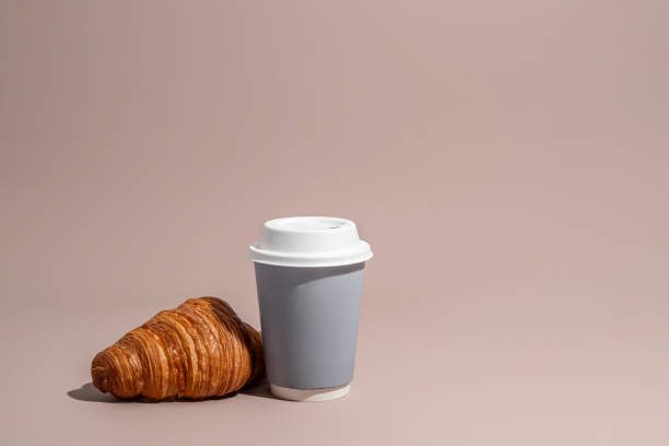istock Takeaway snack, coffee and fresh croissant on beige background 1753701155