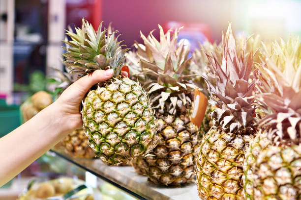 istock Pineapple in hand in shop 1753721554