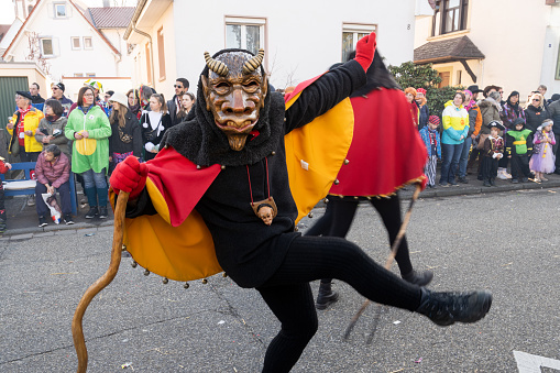 Cologne, Germany - March 3, 2014:  Traditional carnival in Cologne, Germany. A large carnival float moves through the crowds in the streets while spectators cheer and shout for sweets. 