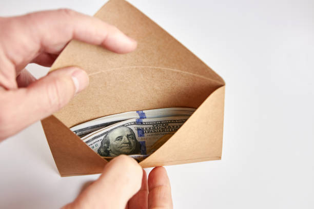 istock Dollar bills in a green envelope. Bribe offer. 1753730077