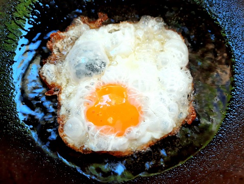 Cooking fried egg - food preparation.