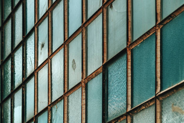 Old factory warehouse grid windows with broken glass as industrial background